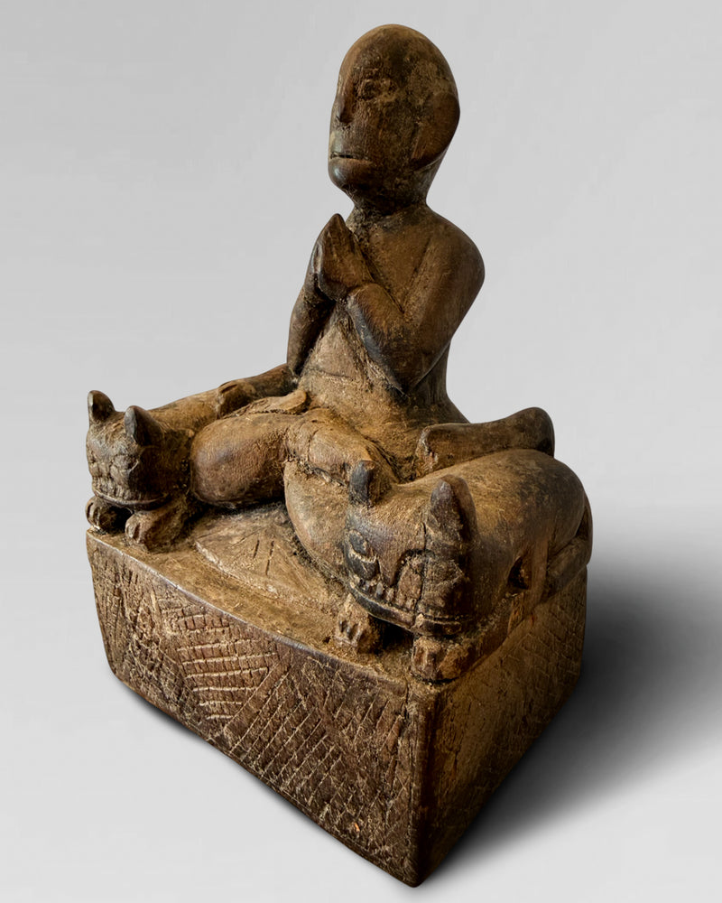 Praying figure with cat guardians