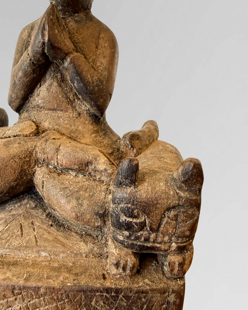 Praying figure with cat guardians
