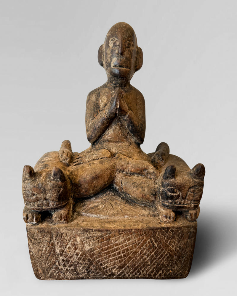 Praying figure with cat guardians