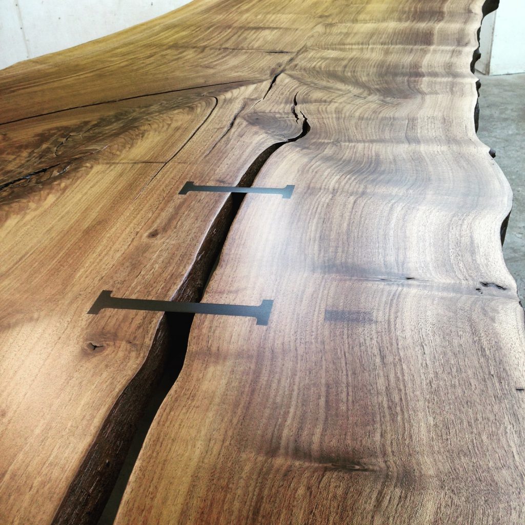 Custom live edge wood slab dining table with a joiners for an elemental crack.