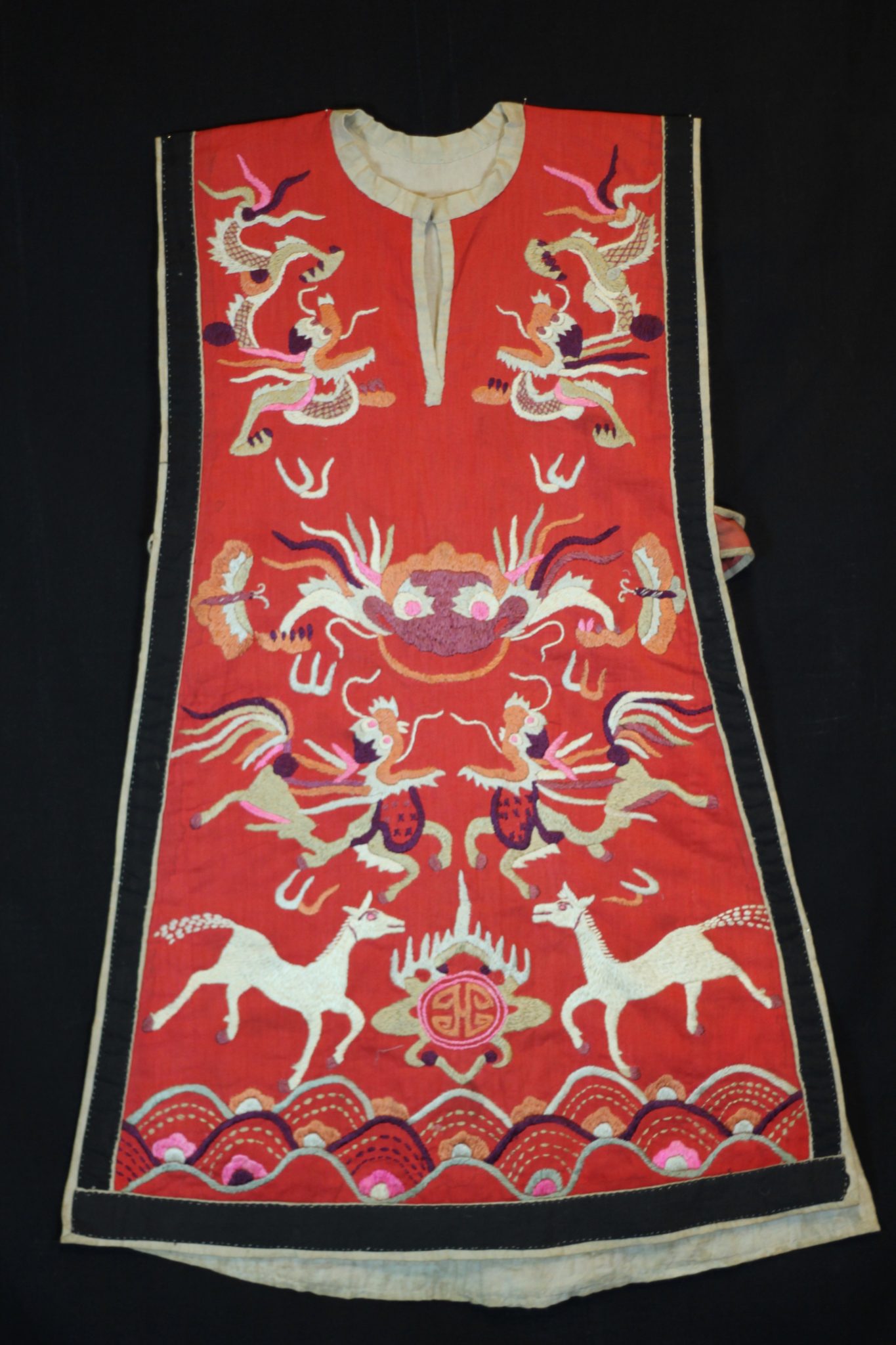 Dragon Tunic Ritual Costume, Vietnam, Tight Trouser Yao people, Mid 20th c, Cotton, silk embroidery. Worn only by high level shaman. The motif typically includes all the deities of heaven to clothe the shaman in the protection of the universe. Not a vain adornment, it is a reminder of man's place in the hierarchical order. Originally a female costume. Long ago shamans were women and men the providers. Not being encumbered by childbirth and rearing, men replaces women as shamans but retained this part of the sacred costume. 34” x 24”, $2800