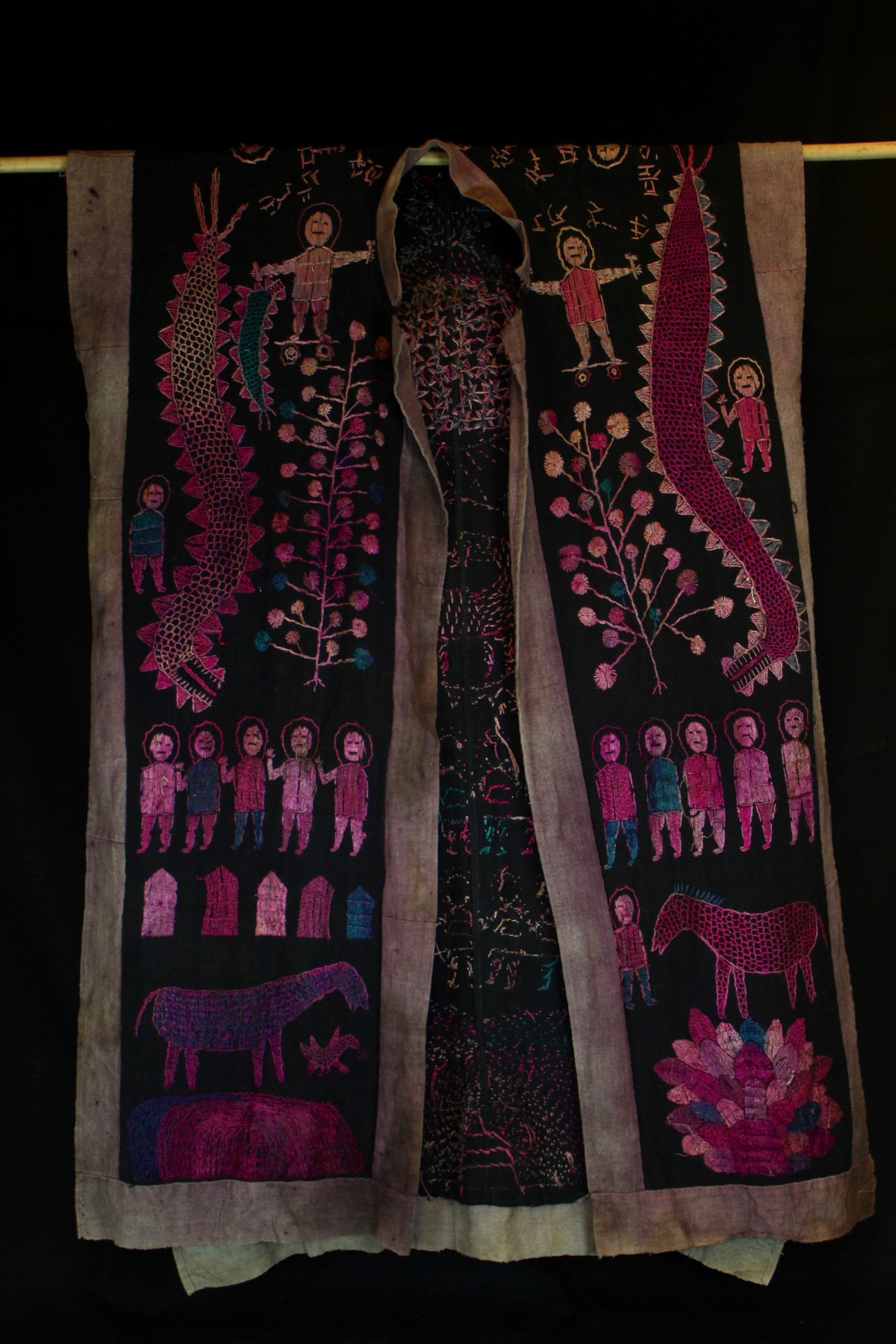 Dragon Robe/Ritual Cloak, Vietnam, (front view) Yao people, Mid 20th c, Cotton, indigo, silk embroidery. Worn only by high level priest/shaman. The motif typically includes all the deities of heaven to clothe the shaman in the universe for protection. Not a vain adornment, it is a reminder of man's place in the hierarchical order. Originally a female costume. Long ago shamans were women and men the providers. Not being encumbered by childbirth and rearing, men replaces women as shamans but retained this part of the sacred costume. 49” x 29”, $2200.