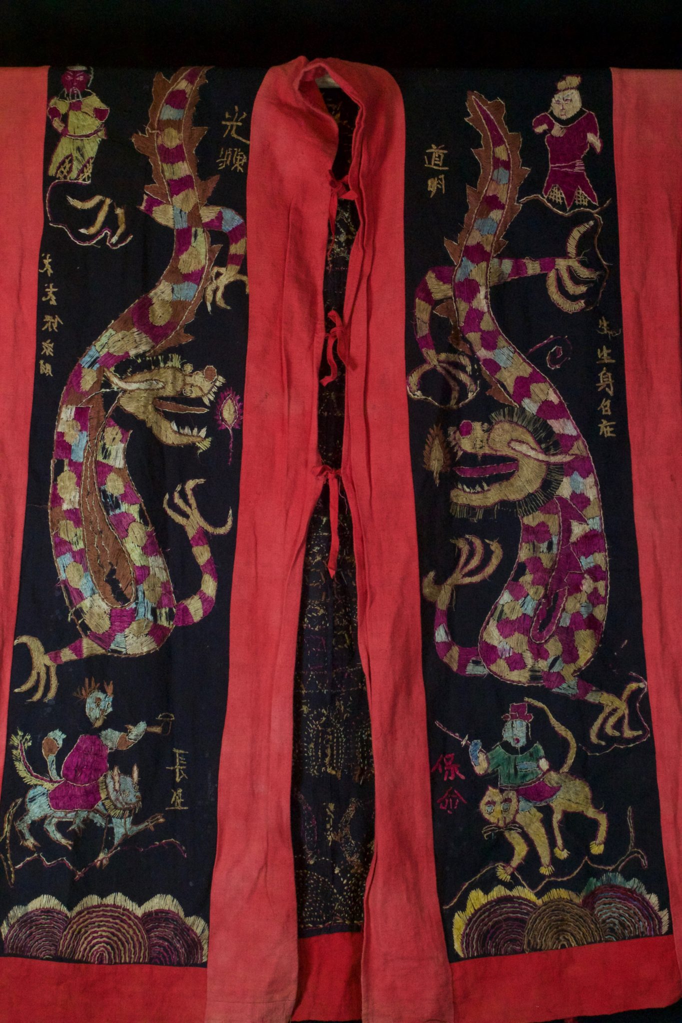 Dragon Robe/Ritual Cloak (front), Vietnam, Tao people, Early to mid 20th c, Cotton, silk embroidery. Worn only by high level priest/shaman for all ceremonies. The motif typically includes all the deities of heaven to clothe the shaman in the universe for protection. Not a vain adornment, it is a reminder of man's place in the hierarchical order. Originally a female costume. Long ago shamans were women and men the providers. Not being encumbered by childbirth and rearing, men replaces women as shamans but retained this part of the sacred costume. 48” x 39”, $2700.