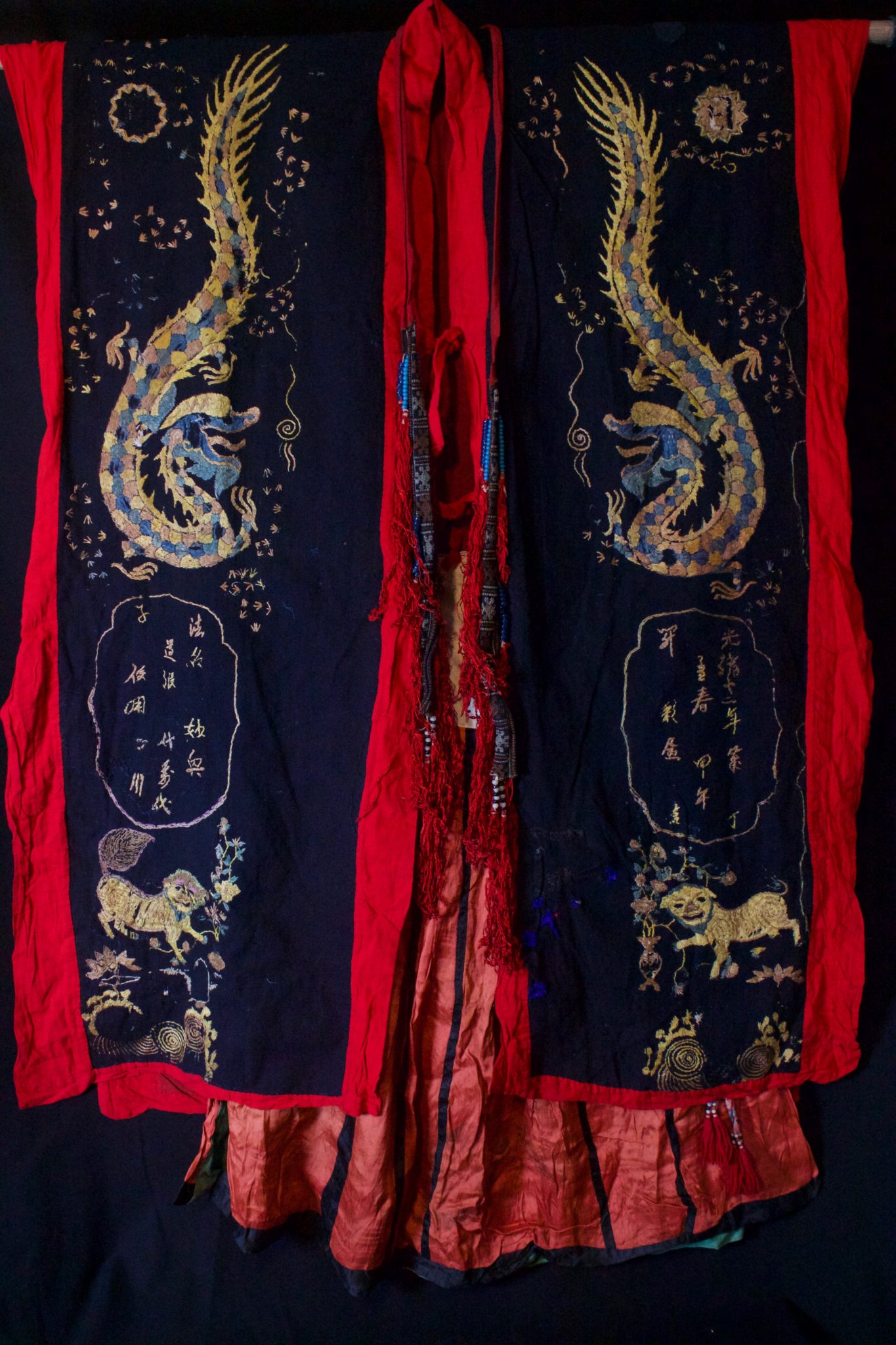 Dragon Robe (front), Shaman Priest's Costume, complete outfit; Robe, Skirt, Belt, ( Scarf see next image), Vietnam, Tao people, Mid 20th c, Cotton, silk embroidery. Worn by shaman/priests for all ceremonies. The motif typically includes all the deities of heaven to clothe the shaman in the universe for protection. Not a vain adornment, it is a reminder of man's place in the hierarchical order. Long ago shamans were women and men the providers. Not being encumbered by childbirth and child rearing, men replaced women as shaman but retained the same sacred costume. This type of headpiece/scarf is worn by postulant or newly ordained shaman. High level priests will wear a hat made of human hair. Dimensions (49” x 42” robe); (35” x 26” skirt); (106” x 3” belt); (118” x 9 ½” scarf), $3900 full costume
