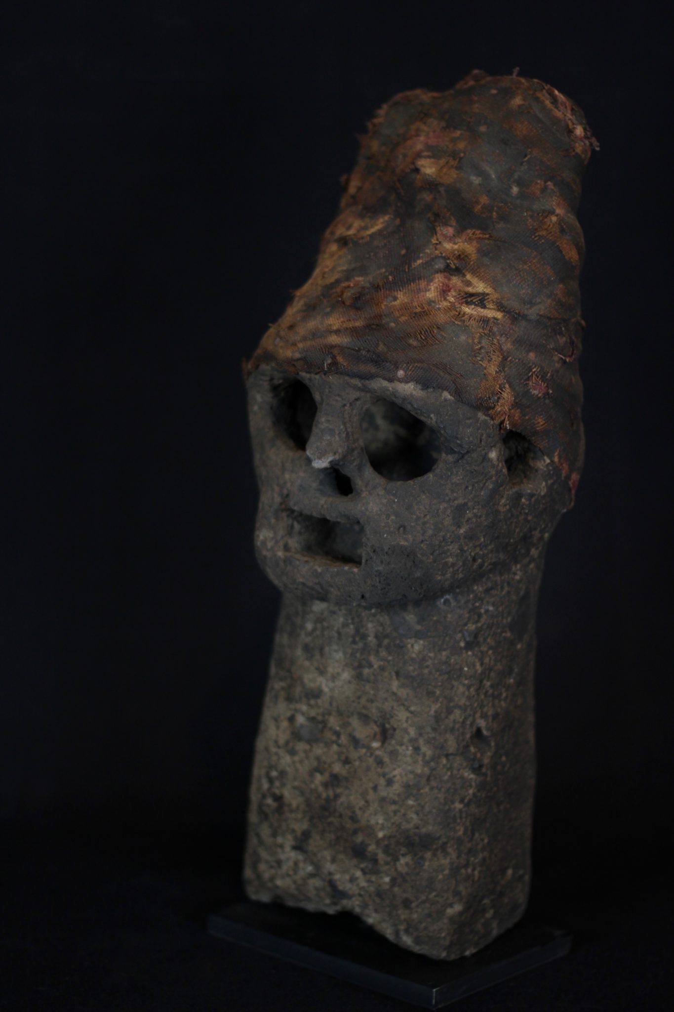 Volcano God Effigy (exceptionally rare), Flores Island, Lesser Sunda Islands, Indonesia, Manga Lewa Village, Mid 18th c, Stone, cloth. Used by shaman for predicting volcanic eruptions. Passed down through four generations. 15” x 5 ½ x 5 ¾”, sold